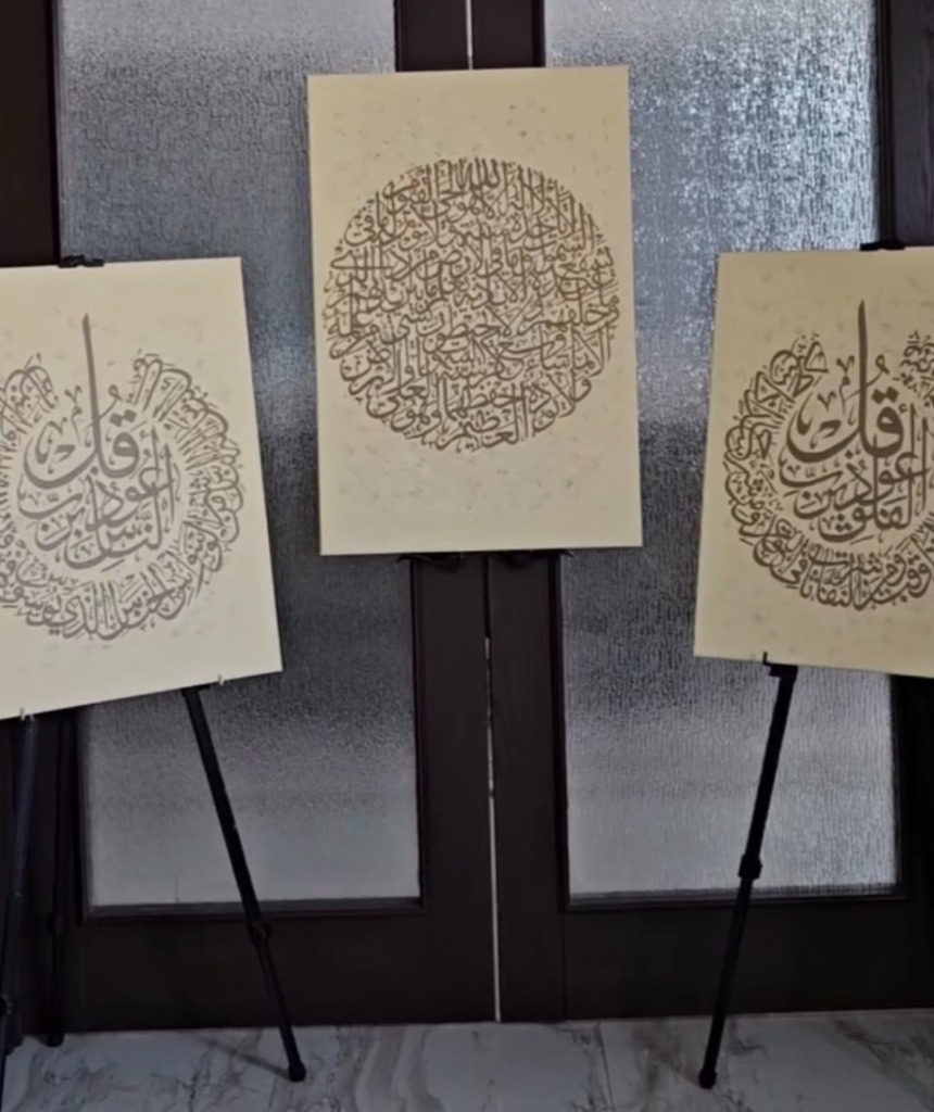 Three Arabic calligraphy paintings on easels — Al-Falaq, Ayatul Kursi, Al-Nas