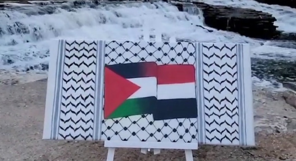 Palestine and Yemen flags on keffiyeh canvas at waterfall